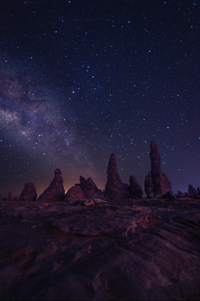 brown rock formation under starry night